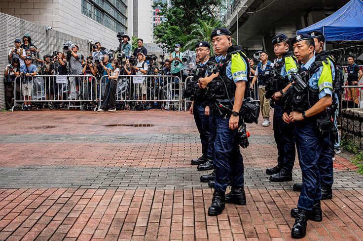 Police officers stand near the media area outside the West