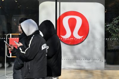 People walk past a Lululemon store, a Canadian brand, in