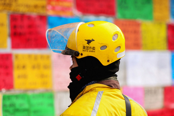 a Meituan food deliveryman looking at employment postings at a