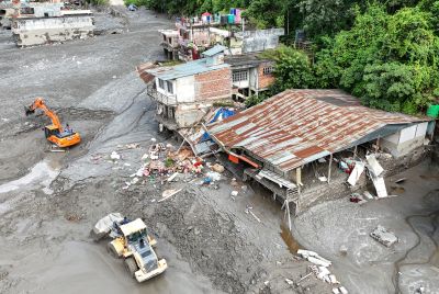An aerial view shows workers using excavators to clear sludge