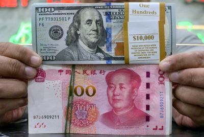 US dollar (top) and Chinese yuan notes are held by