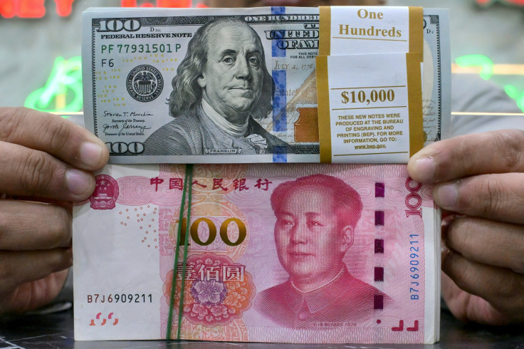 US dollar (top) and Chinese yuan notes are held by