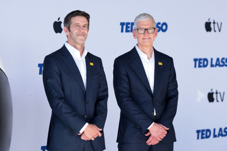 Tim Cook (R), CEO of Apple, walks with John Ternus,
