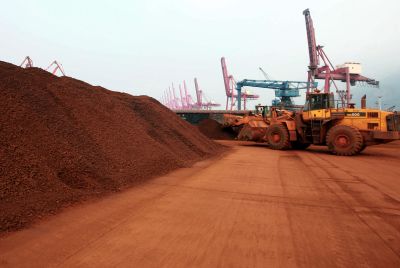 a man driving a front loader shifts soil containing rare